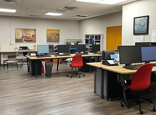 Modern office workspace with multiple desks, computers, and equipment. Omni Build Pro procurement operations office supporting projects across North Carolina.