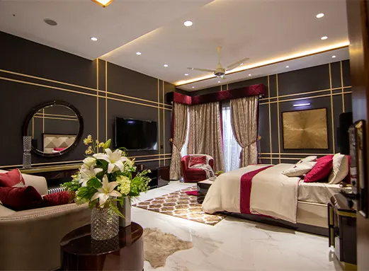 A luxury hotel suite with gold accents and a dark accent wall, demonstrating the hospitality sector expertise of top procurement consulting firms in New York.