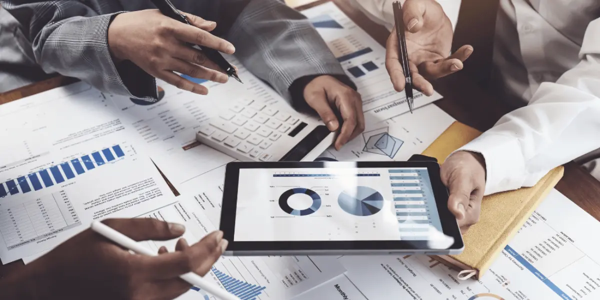Business team reviewing financial reports and data on a tablet